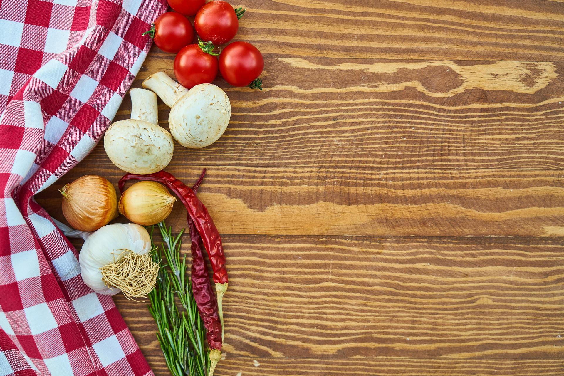Some vegetables and tabelcloth on a wooden slab