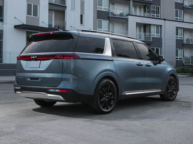 A Kia Carnival parked outside of a building