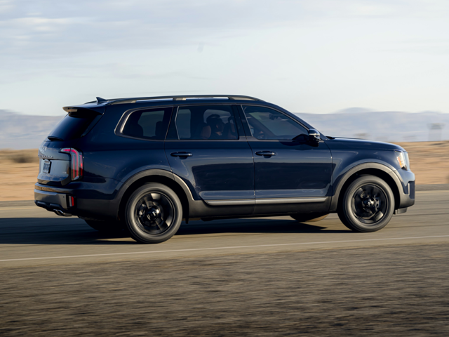 A blue Kia Telluride driving on the road