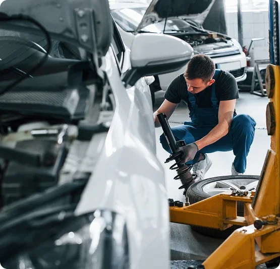 Service technician working on a vehicle suspension in a repair shop