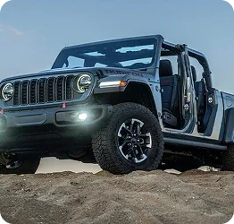 Used Jeep Wrangler Rubicon parked on a sandy hill