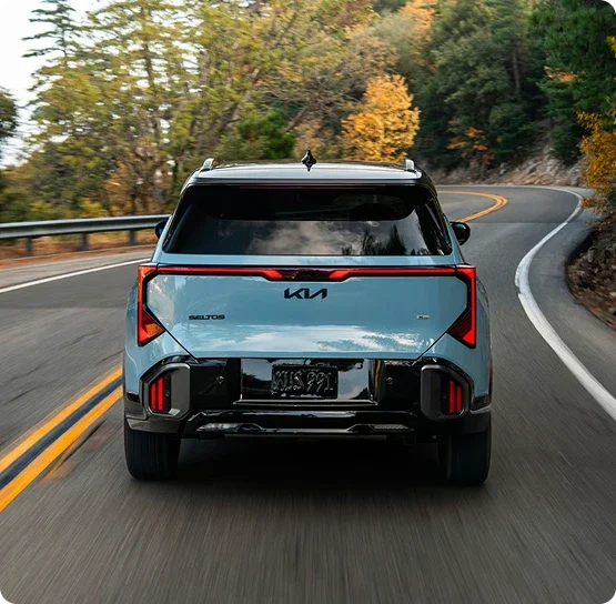 Rear view of a Kia Seltos driving on a winding road