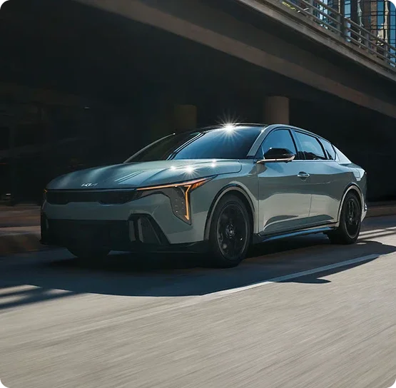 New Kia K4 sedan driving through a city underpass